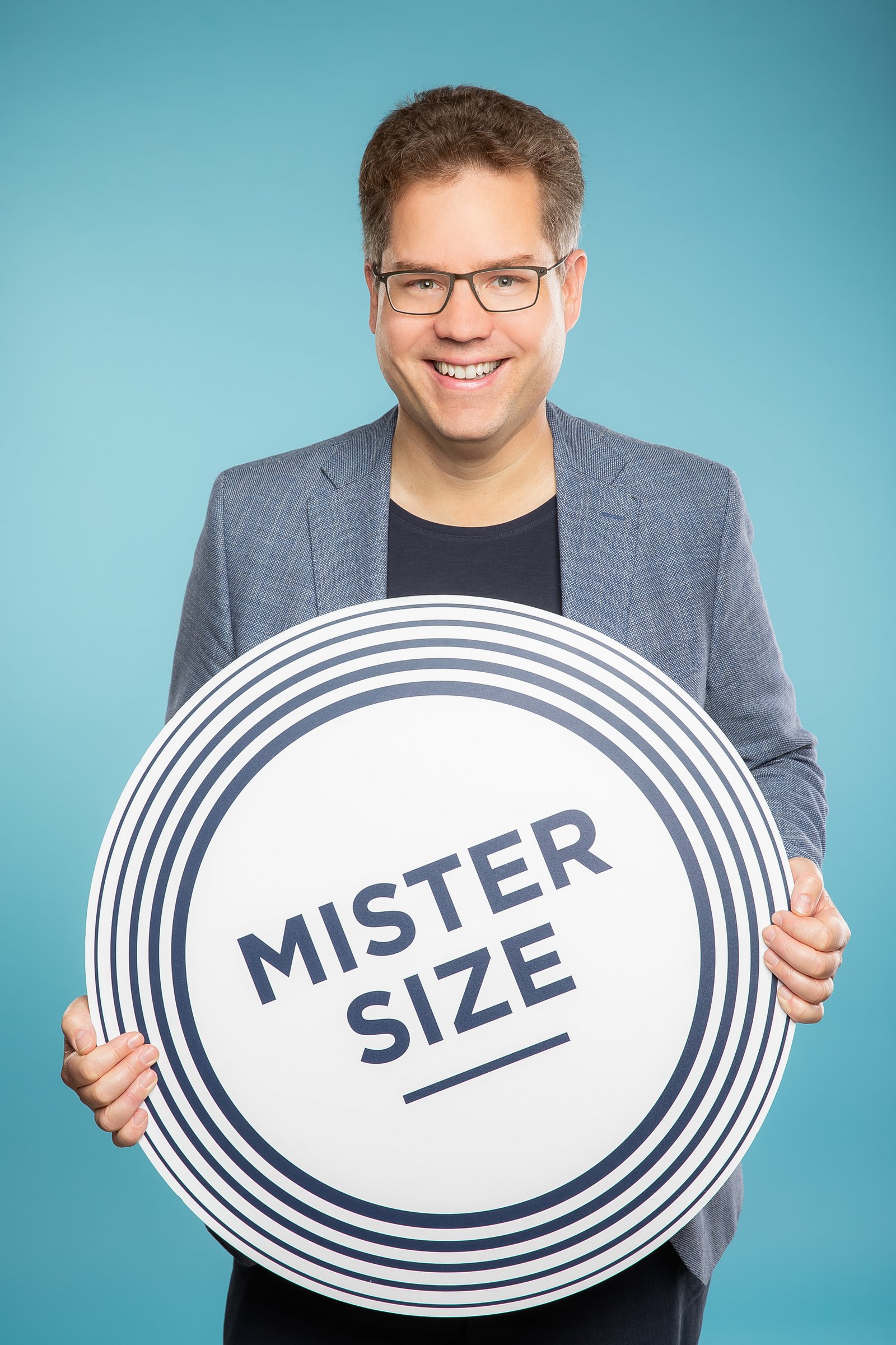 Jan Vinzenz Krause mit einem Mister Size Logo in den Händen