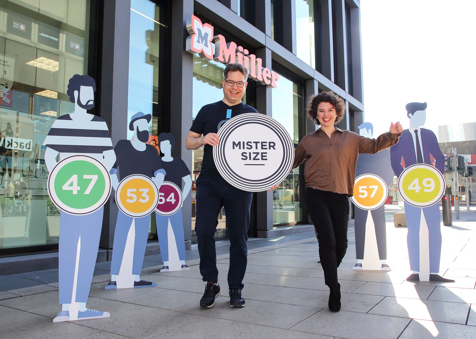 Mister Size Figuren vor dem Müller Drogeriemarkt zusammen mit Jan und Eva Krause