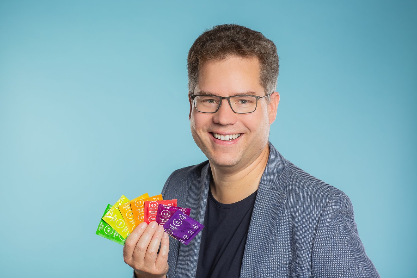 Jan Vinzenz Krause with an assortment of 7 different Mister Size condoms in his hand